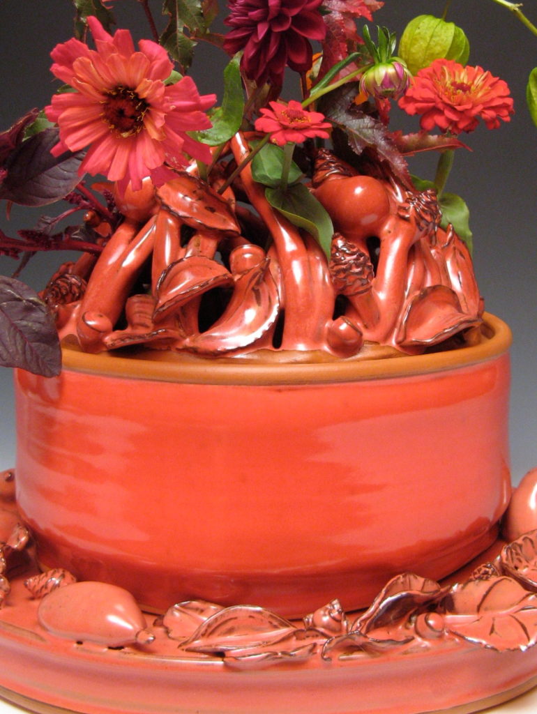 ceramic flower brick by Joan Bruneau with many flowers and creatures