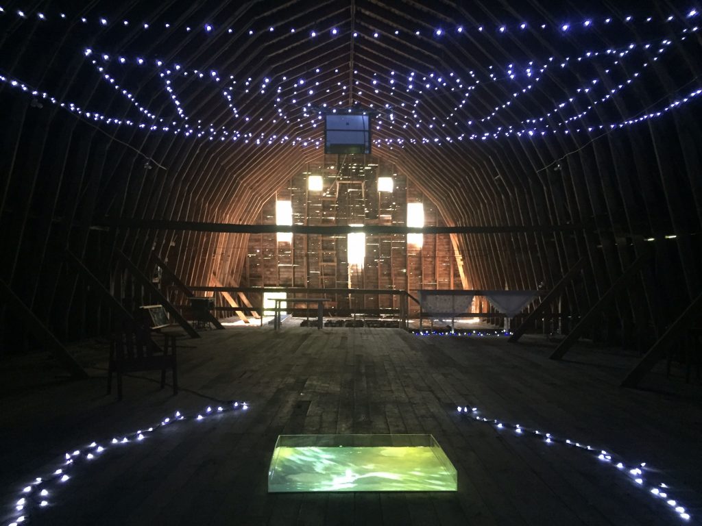 installation showing lights and water in an empty barn